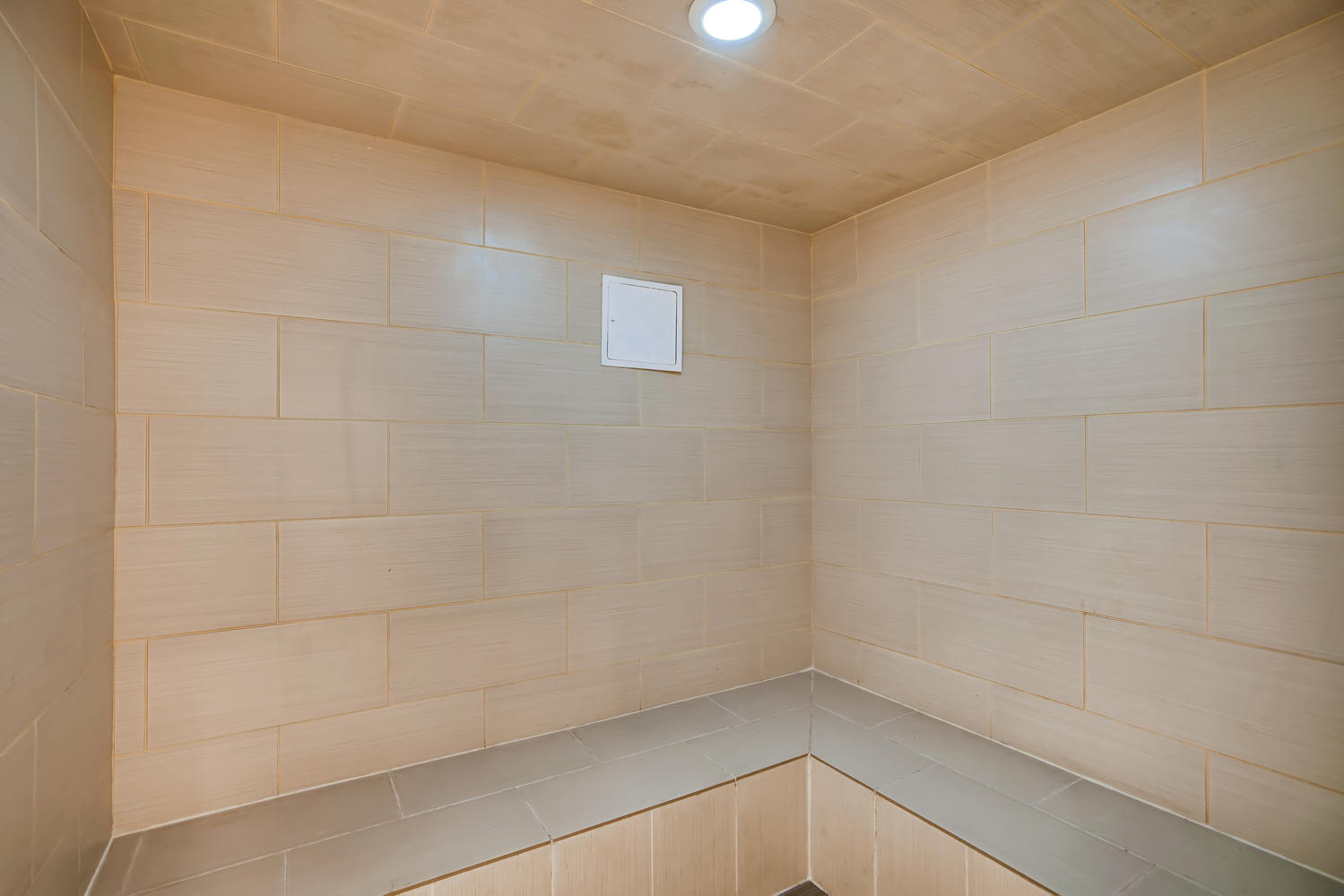 a small bathroom with a tile wall and a window