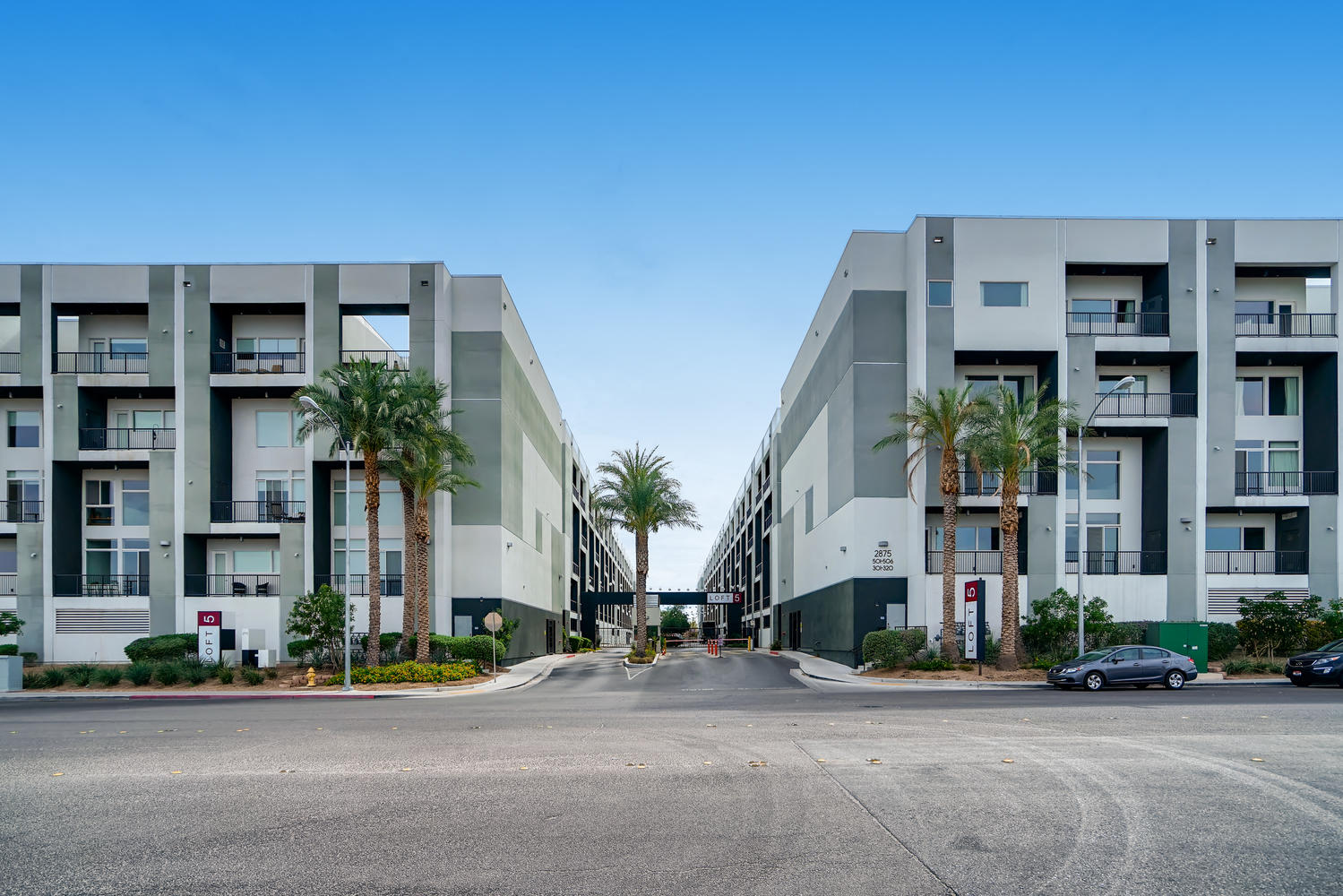 a row of apartment buildings with palm trees