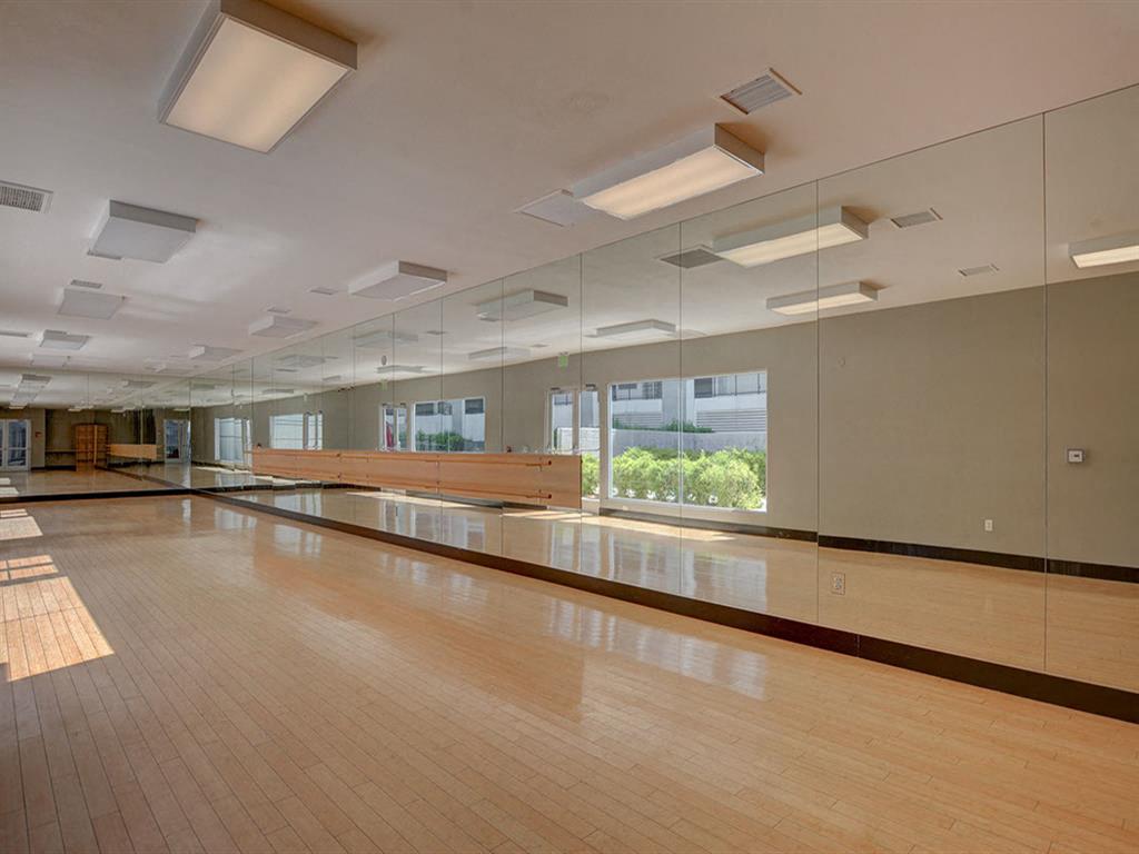 a large room with a wooden floor and mirrors