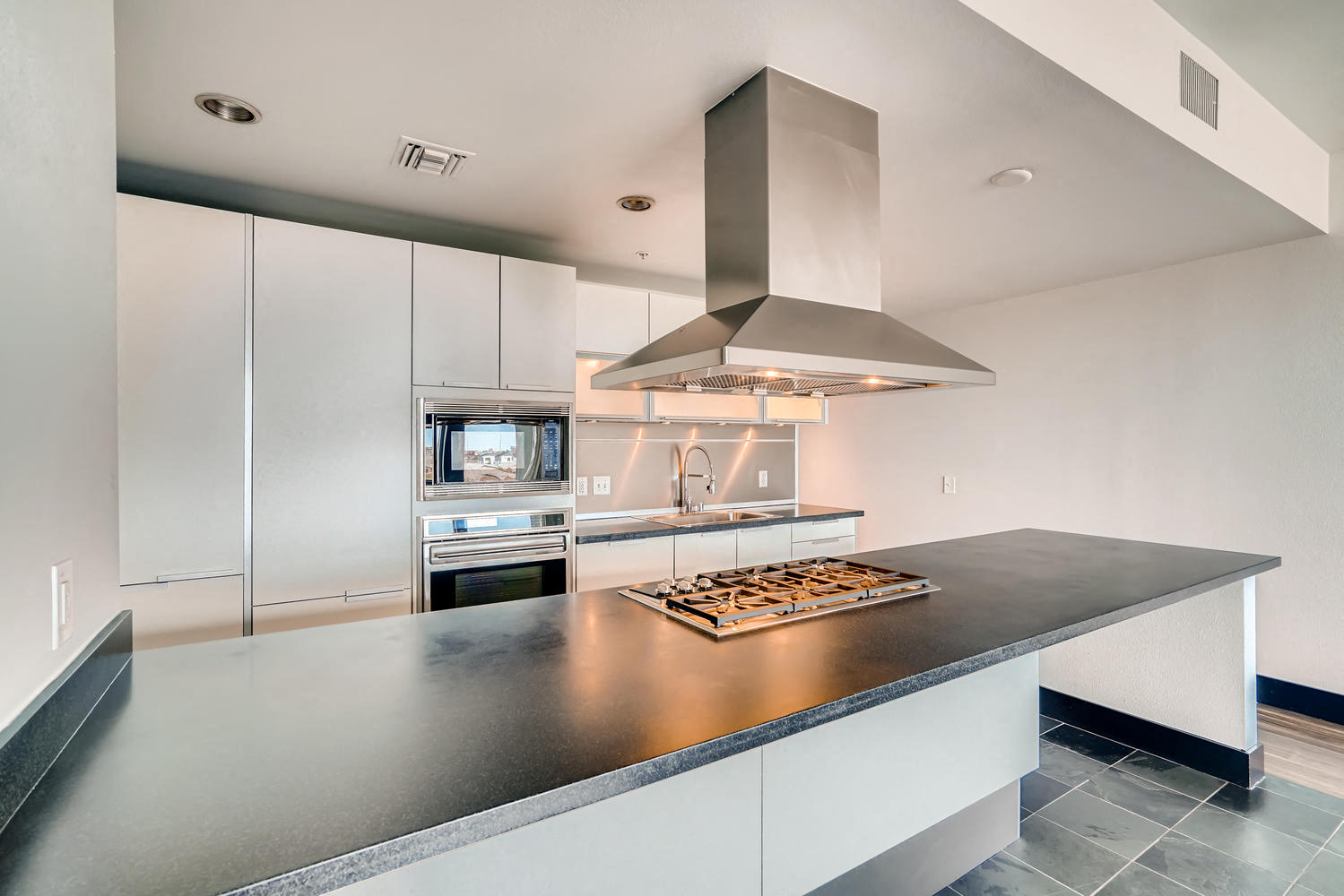 a kitchen with white cabinets and a large counter top