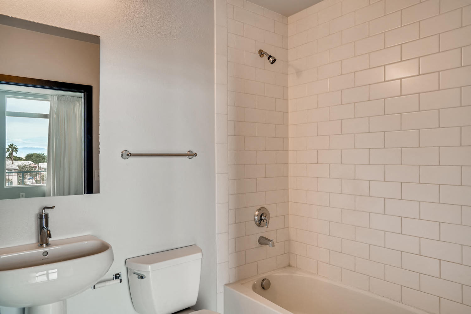 a bathroom with a toilet sink and tub and a mirror