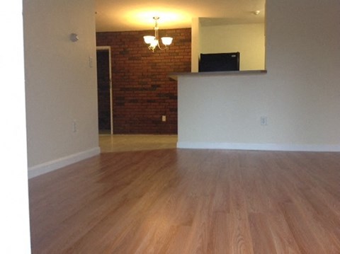 an empty living room with a hard wood floor
