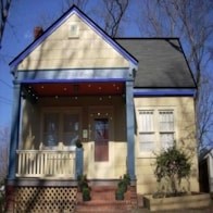 A small house with a porch and a blue trim.