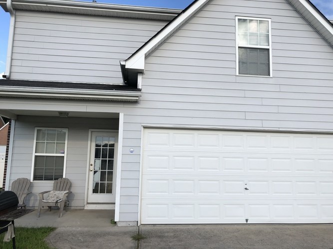 A house with a white garage door and a small porch.