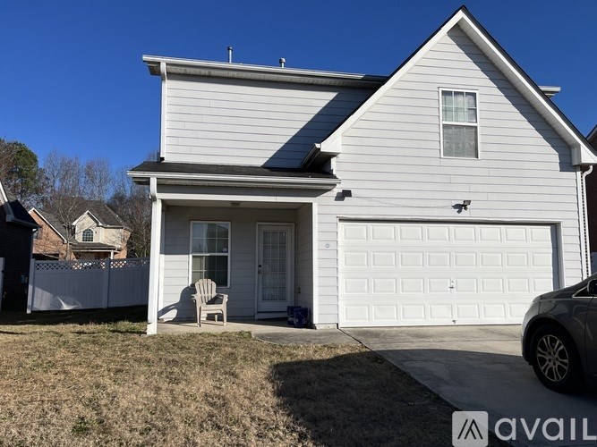 A house with a garage and a car parked in front.