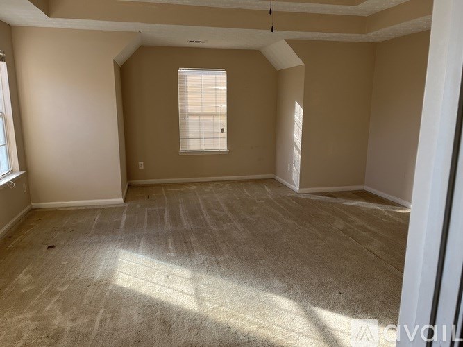 A room with a window and carpeted floor.