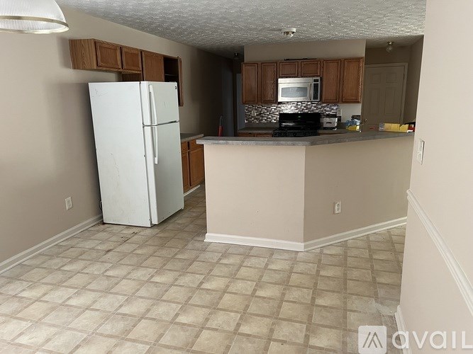 A kitchen with a white fridge and a counter.