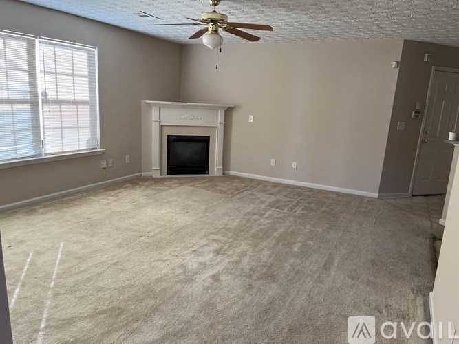 A room with a fireplace and a ceiling fan.