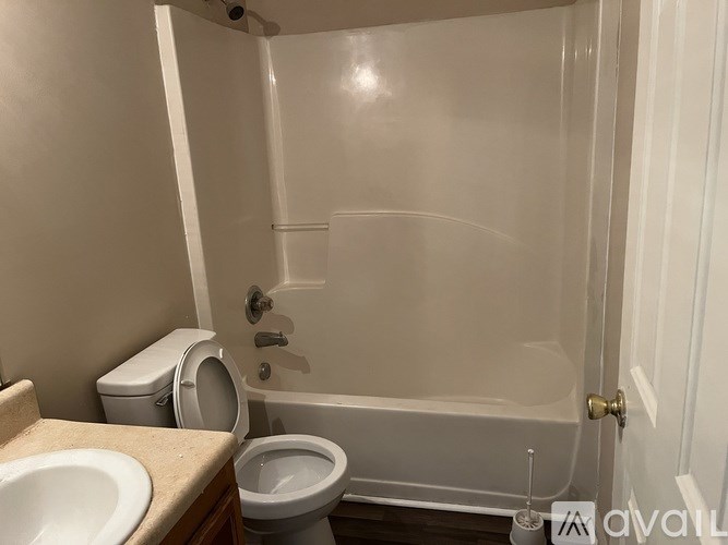 A bathroom with a toilet, sink, and bathtub.