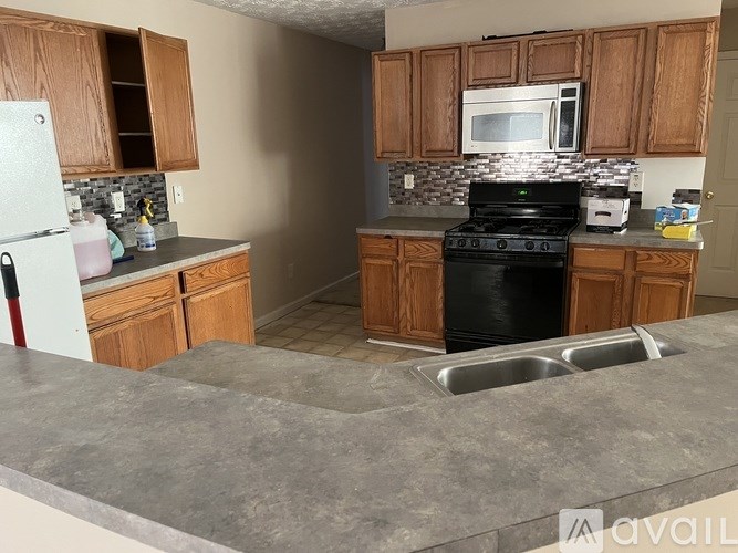A kitchen with wooden cabinets and a black stove top oven.