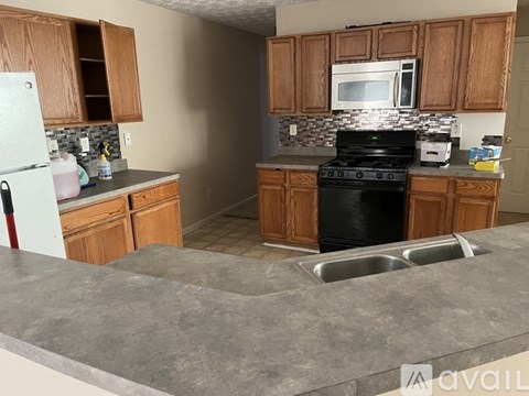 A kitchen with wooden cabinets and a black stove top oven.