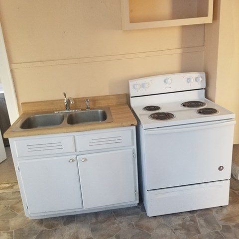 A white stove and sink in a kitchen.