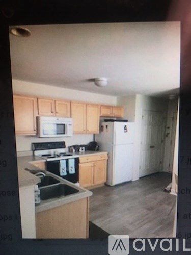 A kitchen with wooden cabinets and a white fridge.