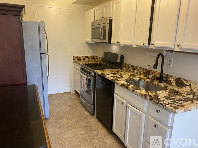 A kitchen with a granite countertop and a black dishwasher.