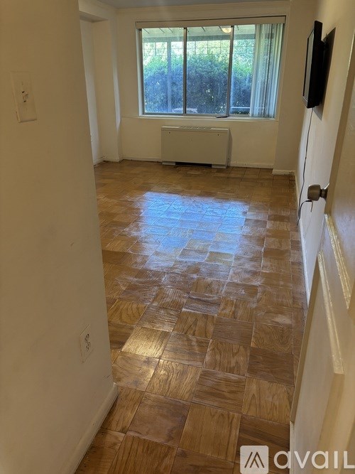 A room with a tiled floor and a window with a view of trees.