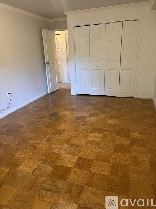 A room with wooden flooring and white walls.