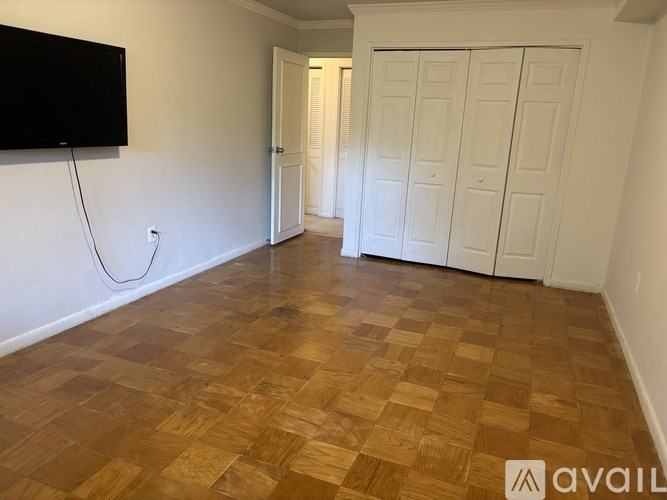 A room with a wooden floor and a white door.
