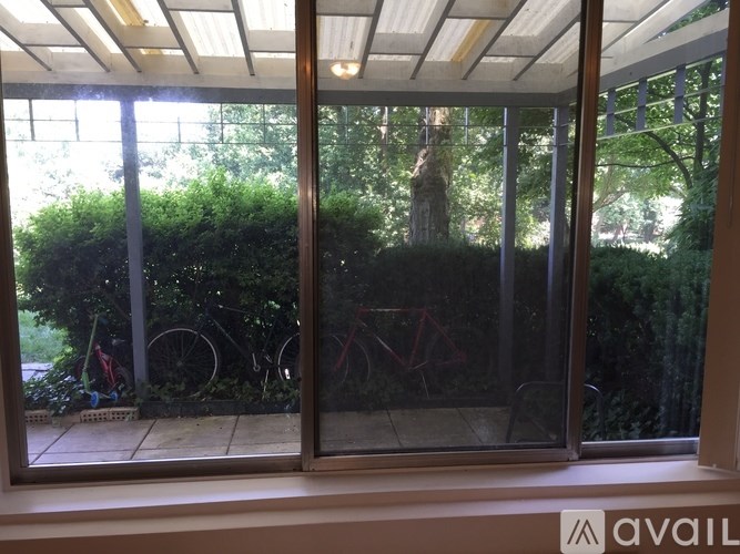 A glass door with a reflection of a bicycle and trees.