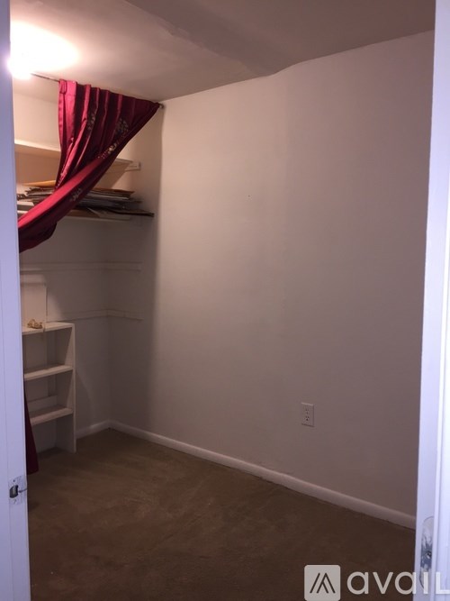 A room with a white door and a red curtain.