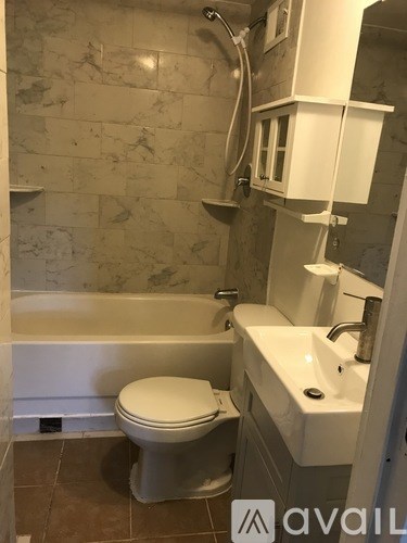A bathroom with a toilet, sink and bathtub.