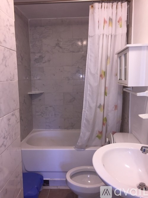 A bathroom with a toilet, sink, and bathtub.