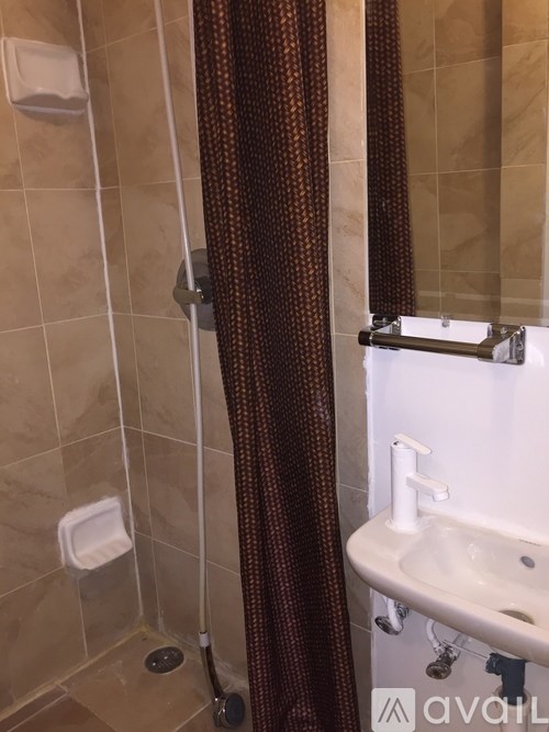 A bathroom with a white sink and brown shower curtain.