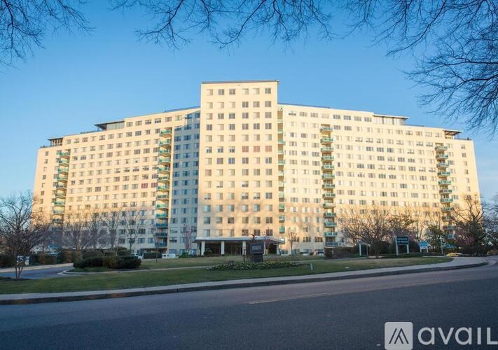 A large, modern apartment building with a parking lot in front.