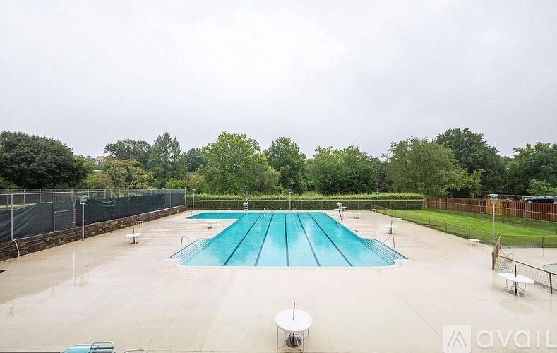 A large outdoor swimming pool surrounded by a fence.