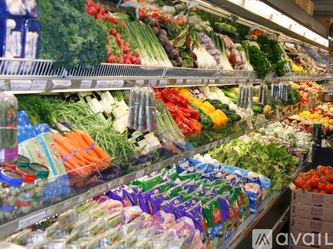 A fresh produce section of a grocery store with vegetables and fruits on display.