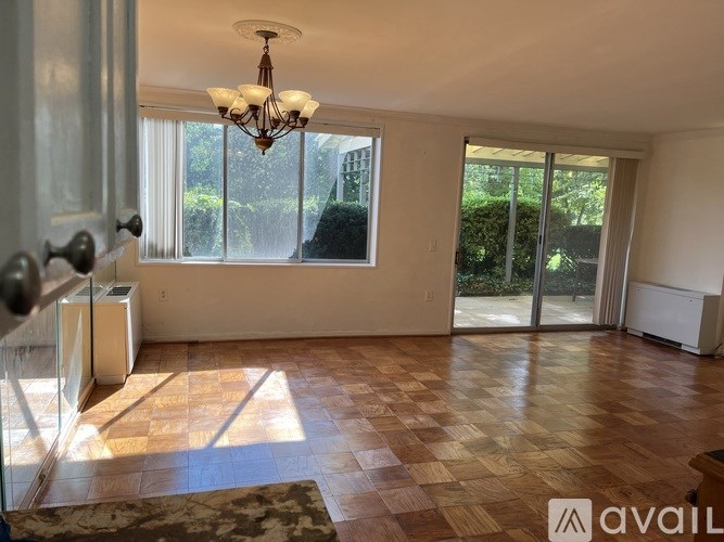 A room with a chandelier, sliding glass doors, and a tiled floor.