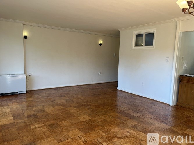 A room with wooden flooring and white walls.