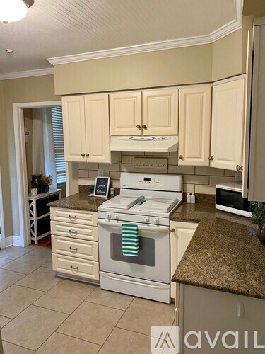 A kitchen with white appliances and cabinets.