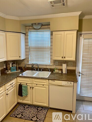 A kitchen with white cabinets and a sink.