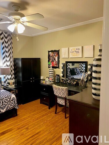 A room with a ceiling fan and a black cabinet.