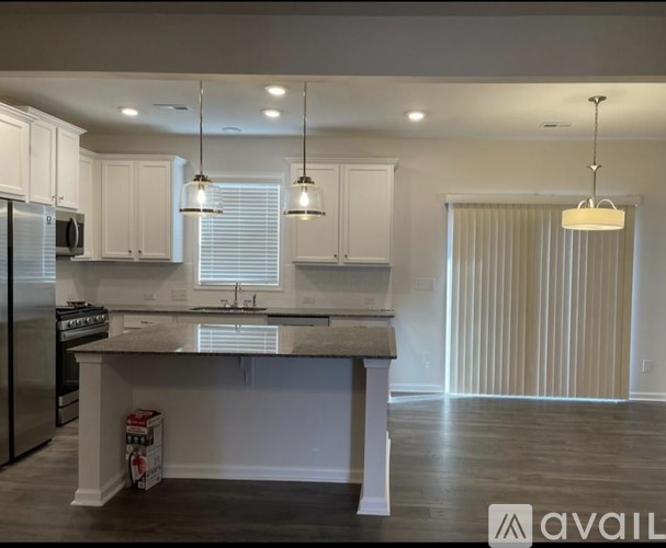 A kitchen with white cabinets and a granite countertop.