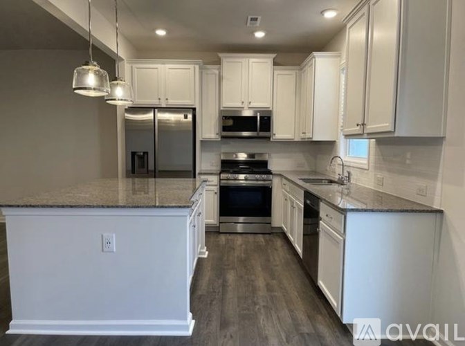 A kitchen with white cabinets and a granite countertop.