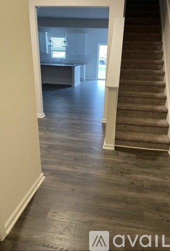 A hallway with a staircase leading to a second floor.
