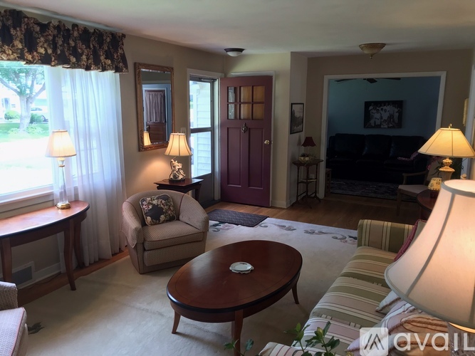 A living room with a brown table and a striped couch.