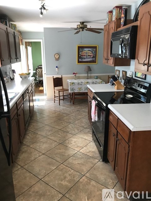 A kitchen with a tile floor and a ceiling fan.