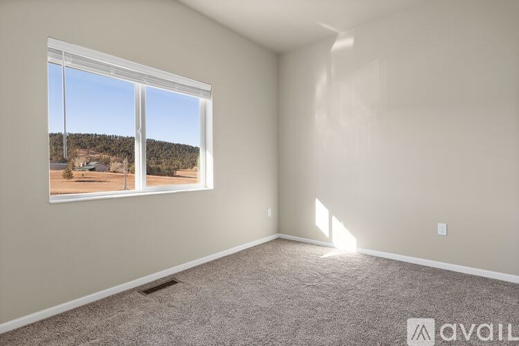 A room with a large window overlooking a landscape.