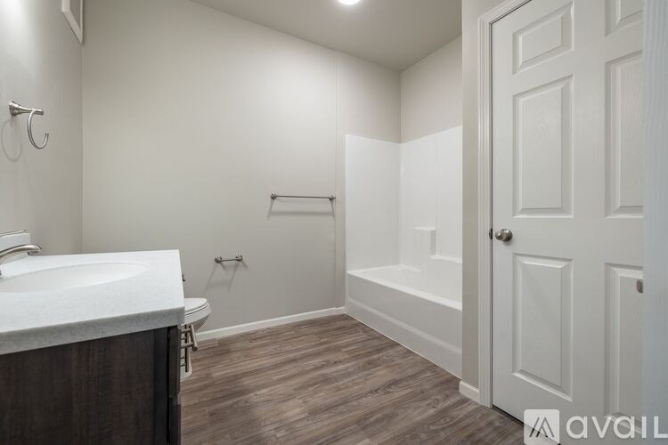 A bathroom with a white sink and a white door.