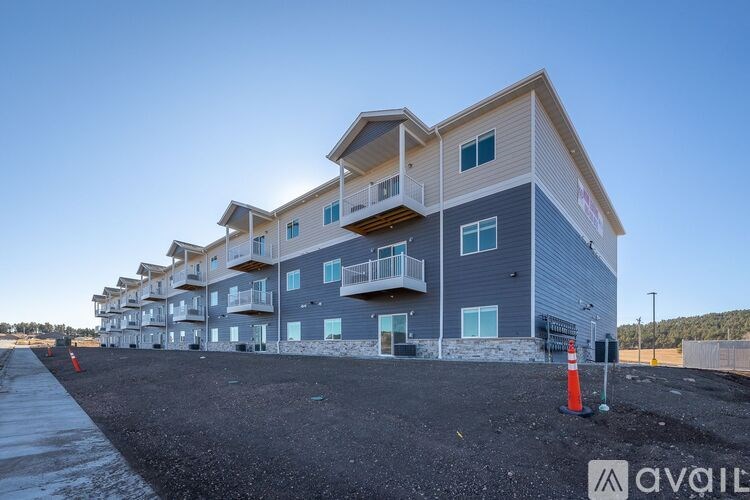 A row of modern townhouses with balconies and a clear sky above.