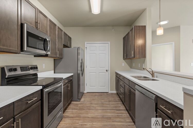 A kitchen with dark wood cabinets and stainless steel appliances.