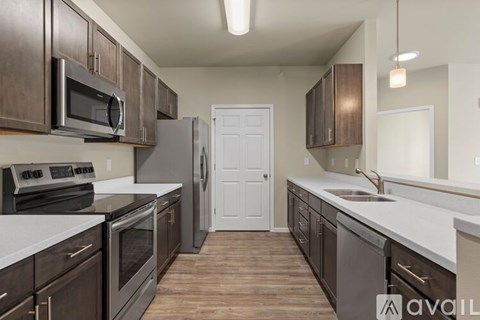 A kitchen with dark wood cabinets and stainless steel appliances.
