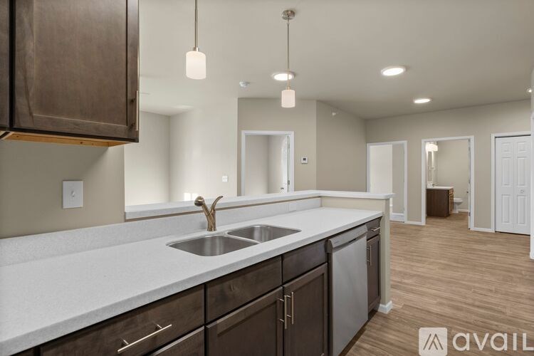 A modern kitchen with dark brown cabinets and a white countertop.