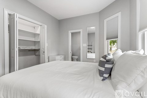 A bedroom with a large bed and a walk-in closet.