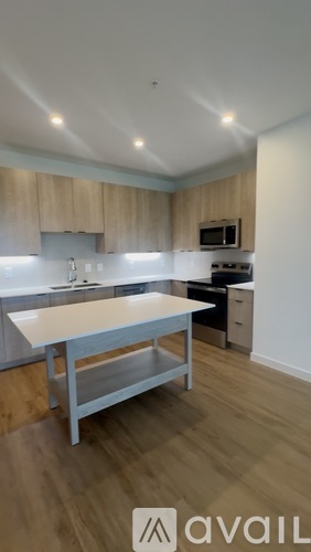 A kitchen with a white counter top and a stainless steel refrigerator.