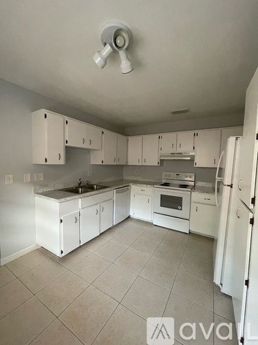 A kitchen with white cabinets and appliances.