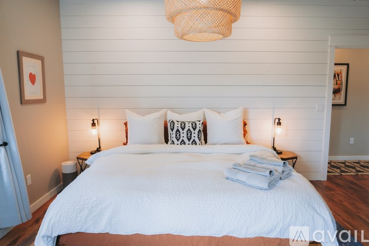 A bedroom with a large bed and a chandelier.