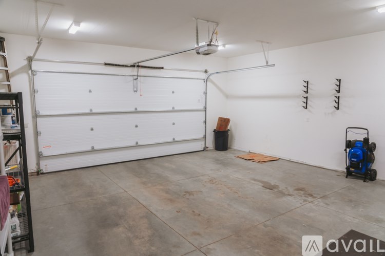 A spray booth with a white wall and a blue machine on the floor.